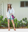 A woman in a cowboy hat and denim shorts standing in front of a cactus wearing the Bed Stu Reina.