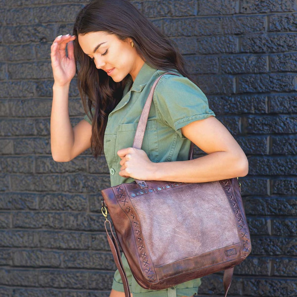 A woman wearing green shorts and a brown Bed Stu Renata LTC leather bag.