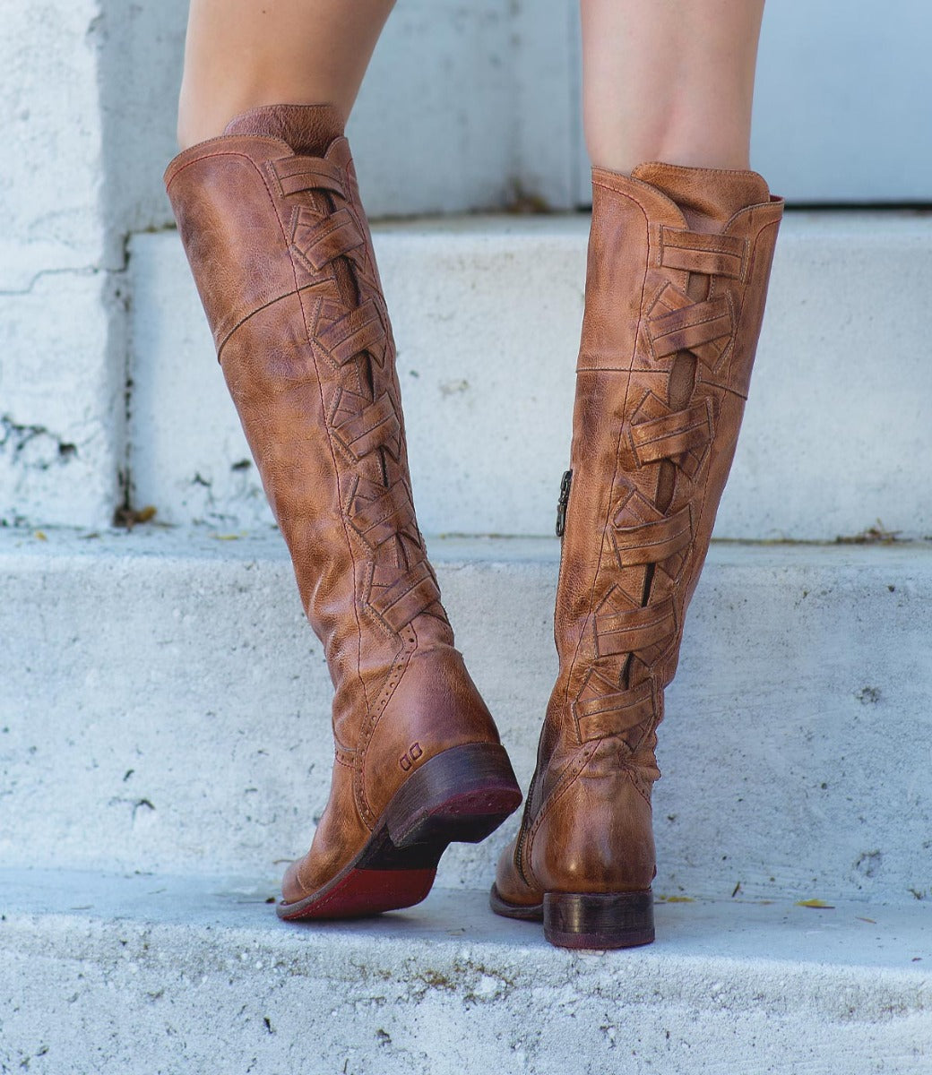 A woman wearing a pair of Rochelle knee high boots from Bed Stu.