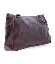 The Rockababy by Bed Stu is a stylish everyday bag perfect for any occasion, featuring decorative stitching, two handles, and a metal ring detail on the top left corner, all crafted from brown leather.