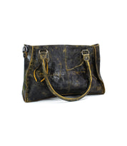 Introducing the Rockababy by Bed Stu: a vintage-style leather handbag featuring dual handles and a worn, distressed finish. Perfect for everyday use, it boasts a spacious design with eye-catching stitching details.