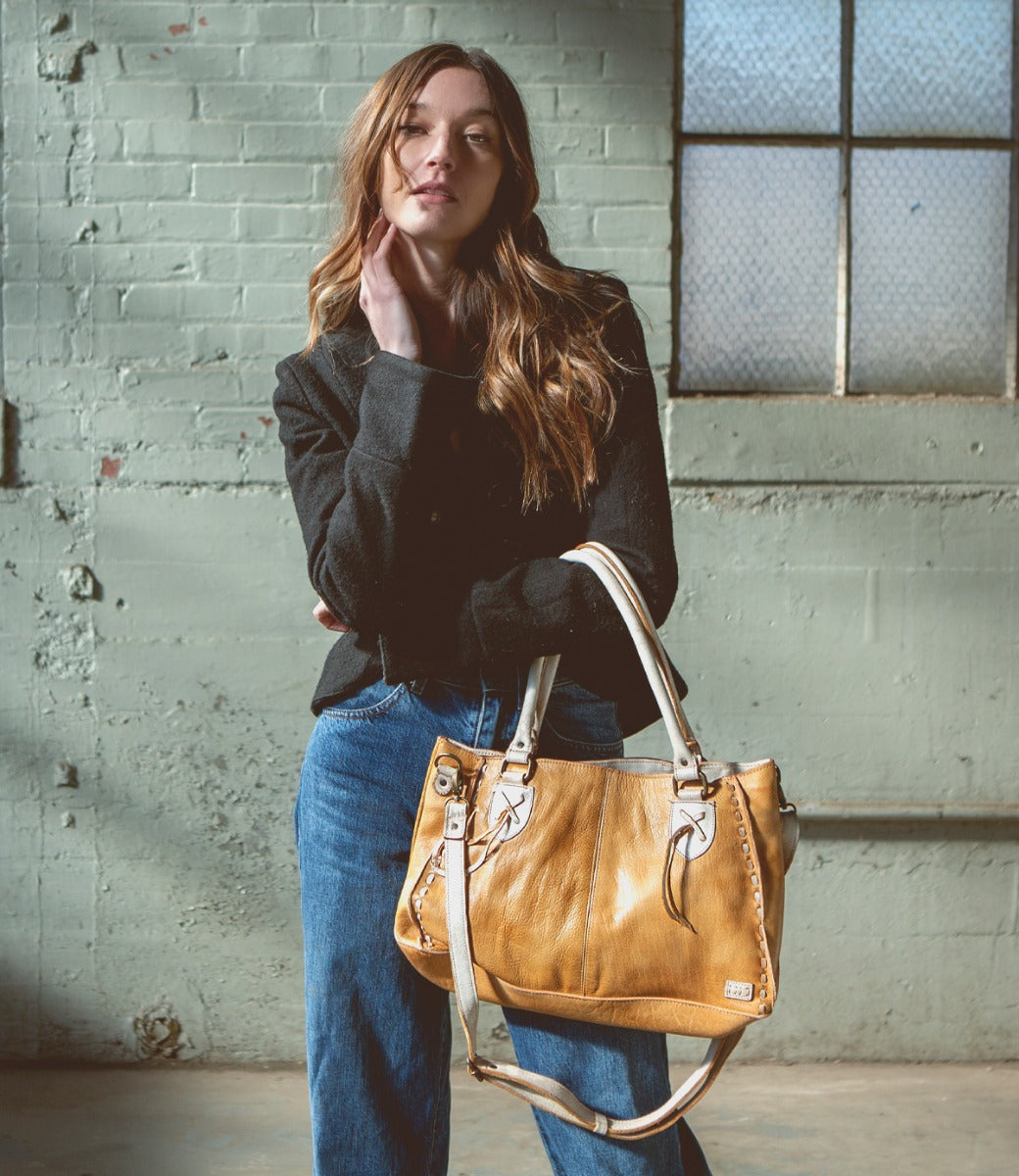 A woman wearing jeans and a Rockababy leather bag by Bed Stu.