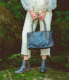 A woman holding a Rockababy leather handbag by Bed Stu.