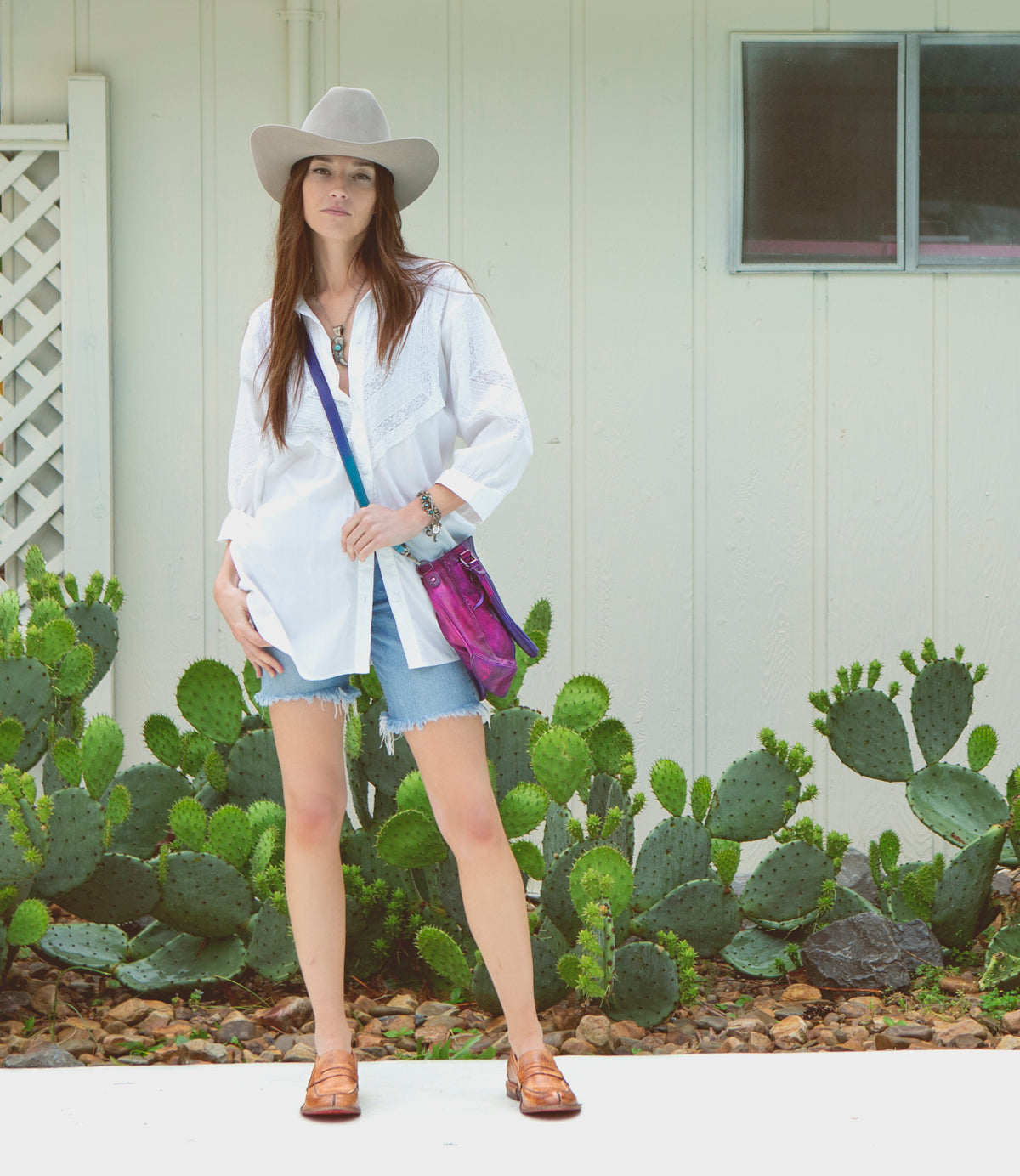A woman in a cowboy hat and denim shorts wearing a Rockababy bag.