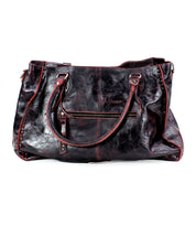 A best-selling large black leather handbag with red stitching from Bed Stu, known as Rockaway, features two handles, a front zipper pocket, and visible creases, though it shows signs of wear.