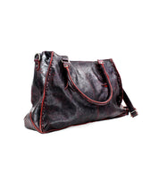 The Bed Stu Rockaway is a large black leather handbag with red stitching, featuring double handles and an adjustable shoulder strap. This best-selling bag effortlessly combines style with functionality.