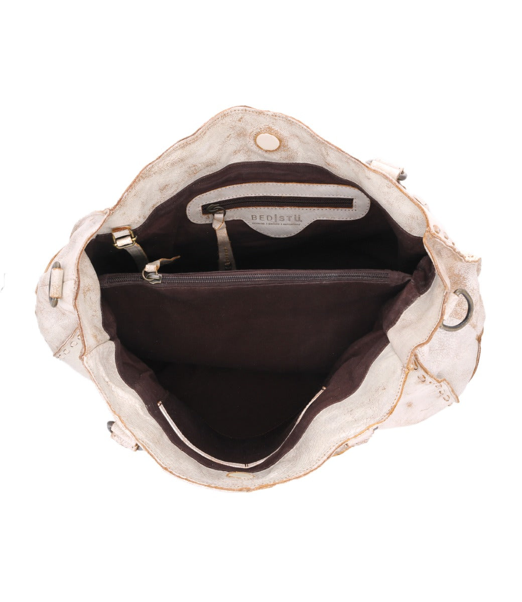 The inside of a white Bed Stu Rockaway handbag with a gold zipper.