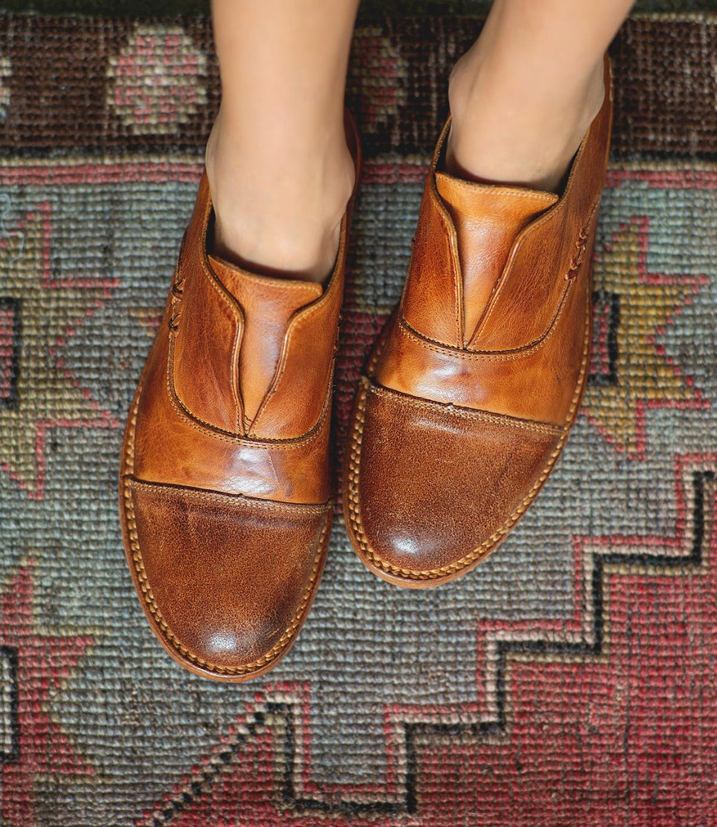 A pair of Bed Stu Rose brown leather shoes standing on a rug.