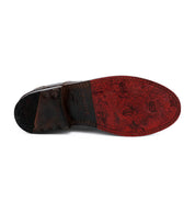 A pair of Bed Stu men's shoes with a red sole.