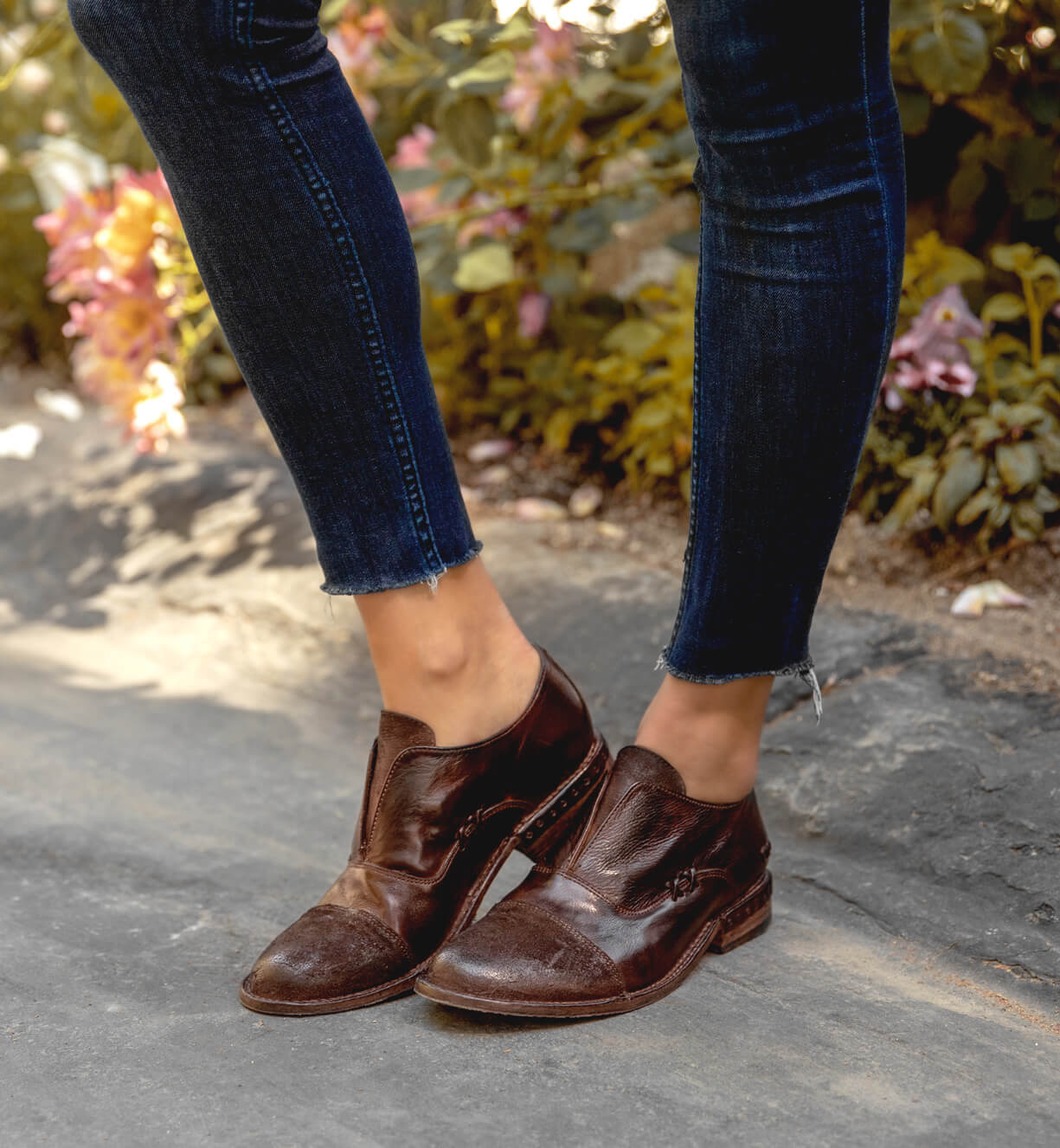 A woman wearing jeans and a pair of Bed Stu Rose shoes.