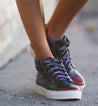 A woman wearing a pair of purple Bed Stu Rossela high top sneakers.