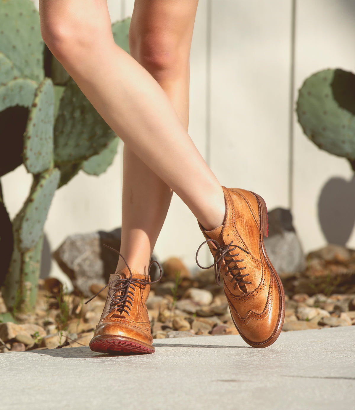 A woman wearing a pair of Bed Stu Sally wingtip boots.