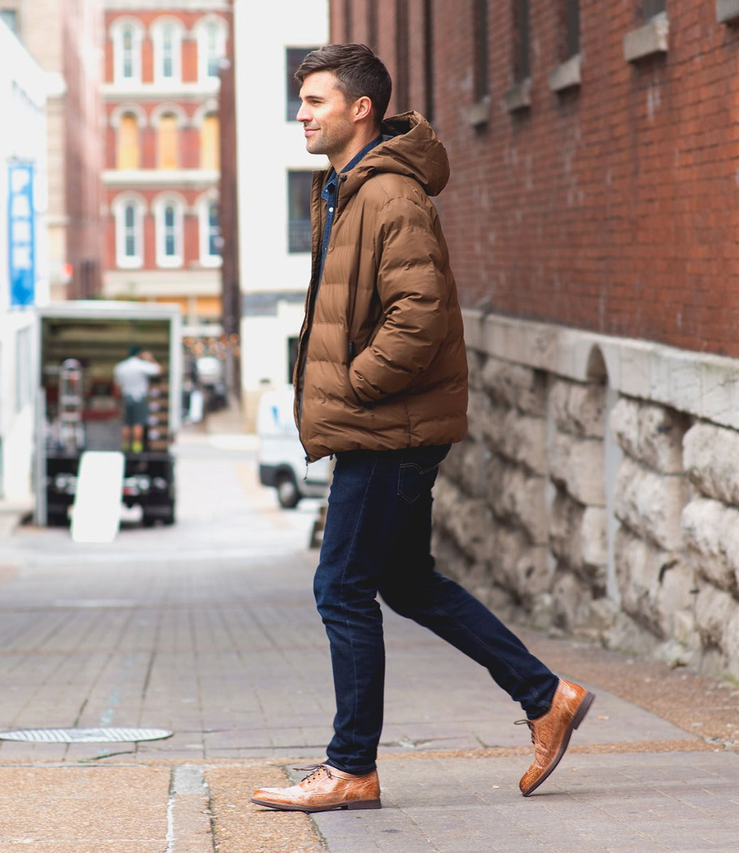 A man wearing Bed Stu Sandro leather shoes walking down a street.