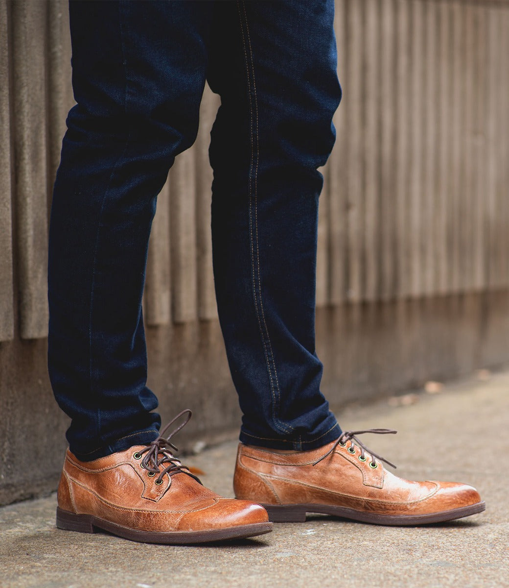 A man wearing a pair of Bed Stu Sandro brown oxford shoes.