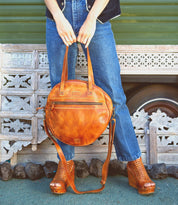 A woman wearing jeans and a Bed Stu Saray leather bag.
