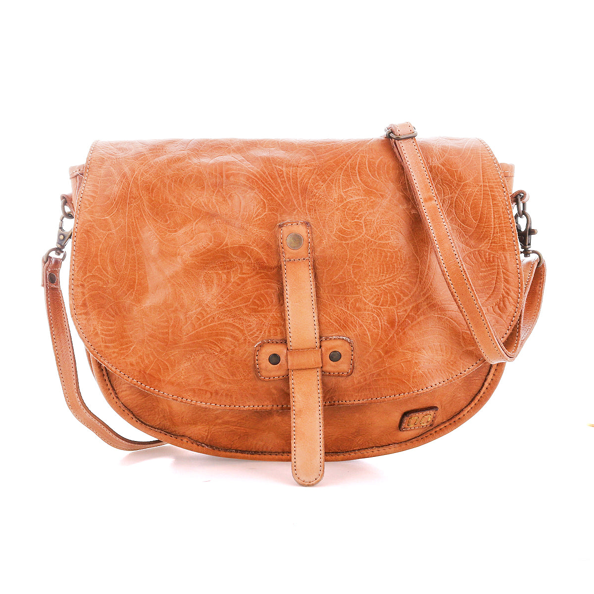 The Bed Stu Sequoia EM is a light brown vegetable-tanned leather crossbody saddle bag with a front strap closure, embossed floral pattern, and adjustable crossbody strap for comfort.