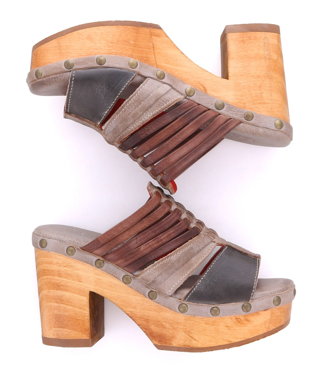 Two Bed|Stü Shantel wooden platform sandals featuring smooth leather straps and a cushioned leather insole are arranged heel to toe, forming an hourglass-like shape against a white background.