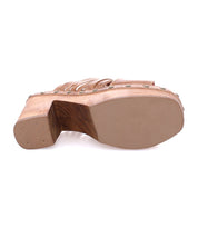 The bottom view of the Bed|Stü Shantel showcases its thick wooden platform sole, visible metal rivets, and light brown finish, highlighting the sandal’s cheerful clog design with a woven upper and stylish appeal.