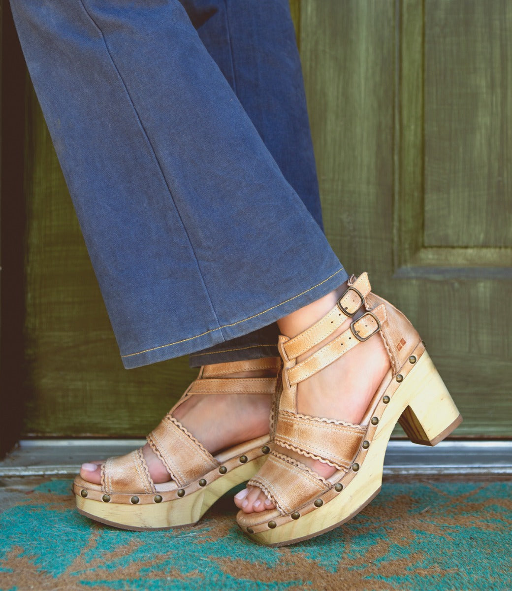 A woman's feet in a pair of Bed Stu Sloane sandals.