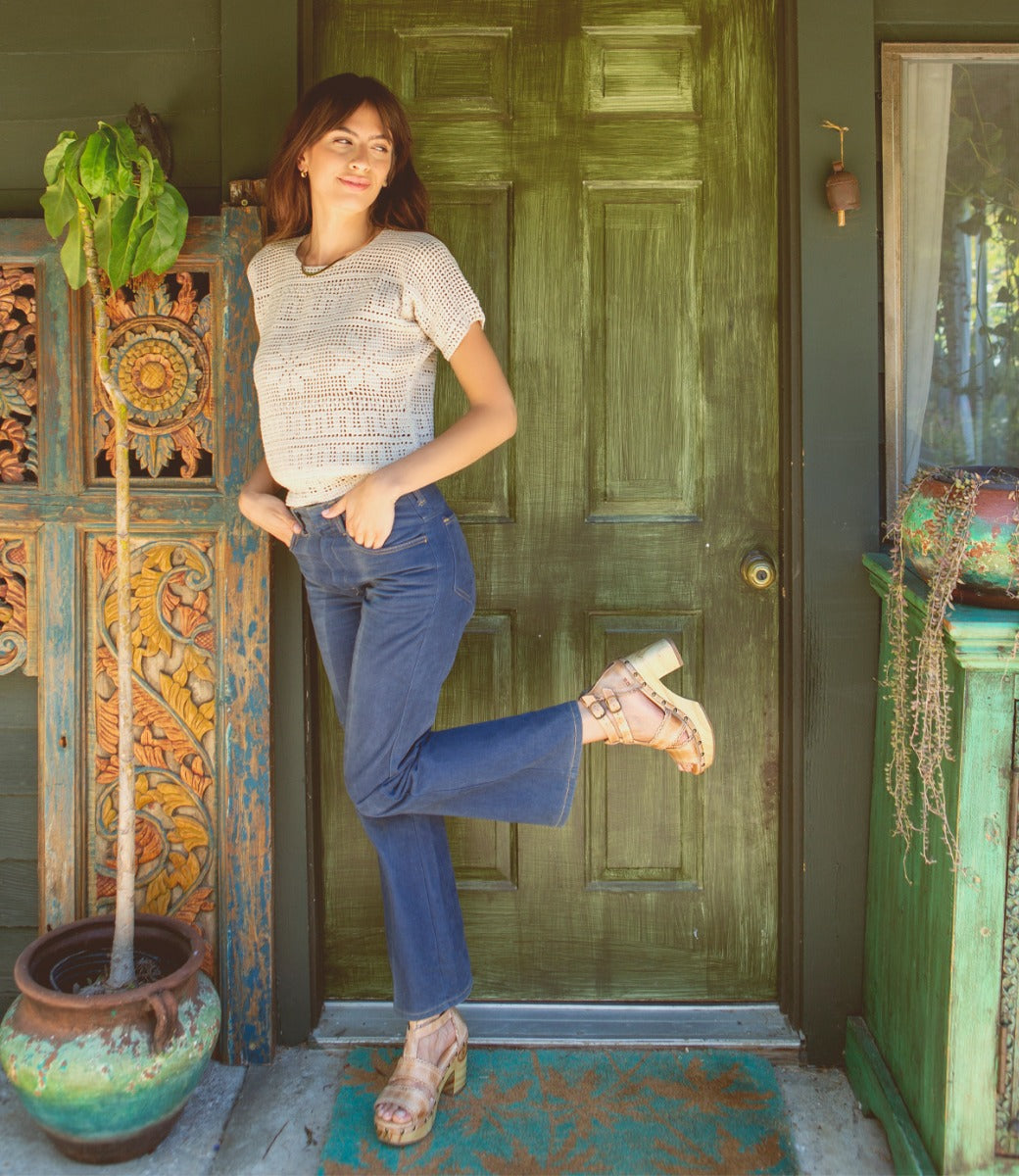 A woman posing in front of a green door wearing Sloane by Bed Stu.