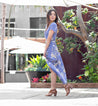 A woman wearing a blue floral Sona maxi dress and Bed Stu sandals.