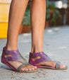 A woman's in a pair of purple Bed Stu Soto sandals.