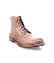 A single worn brown leather lace-up Spiker ankle boot with blue laces on a white background. (Brand Name: Bed Stu)