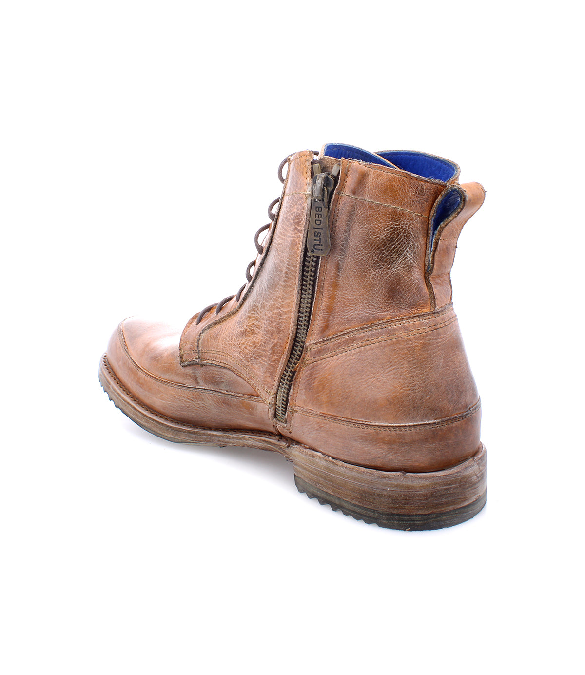 A pair of worn brown leather Bed Stu Spiker lace-up ankle boots with zippers, isolated on a white background.