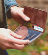 A person holding a Stardust wallet with a passport in it.