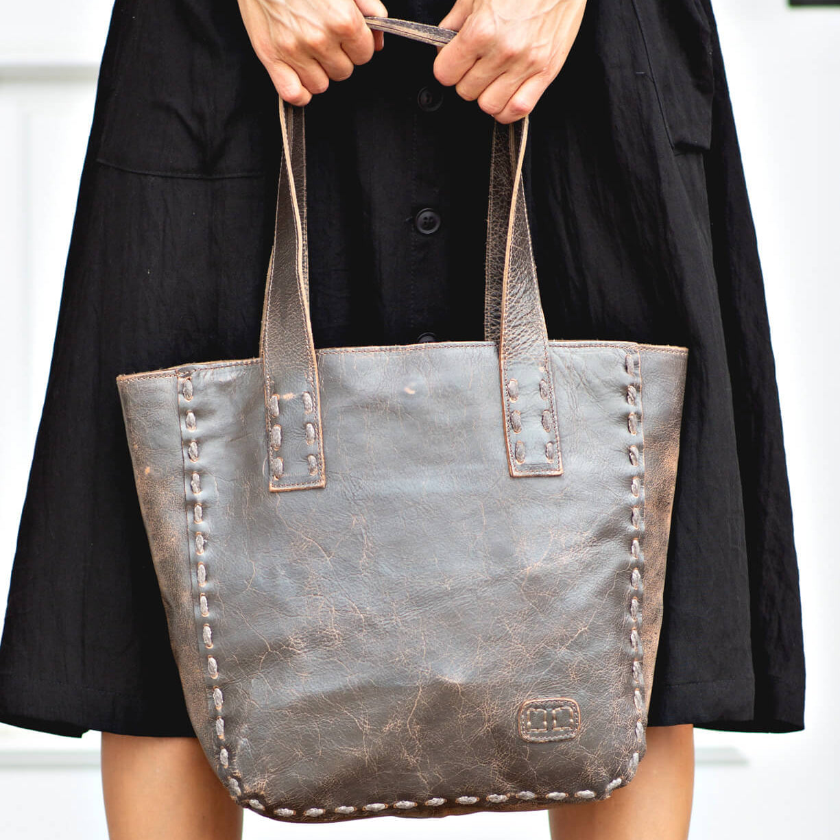 A woman is holding a Stevie tote bag by Bed Stu.