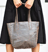 A woman is holding a Stevie tote bag by Bed Stu.