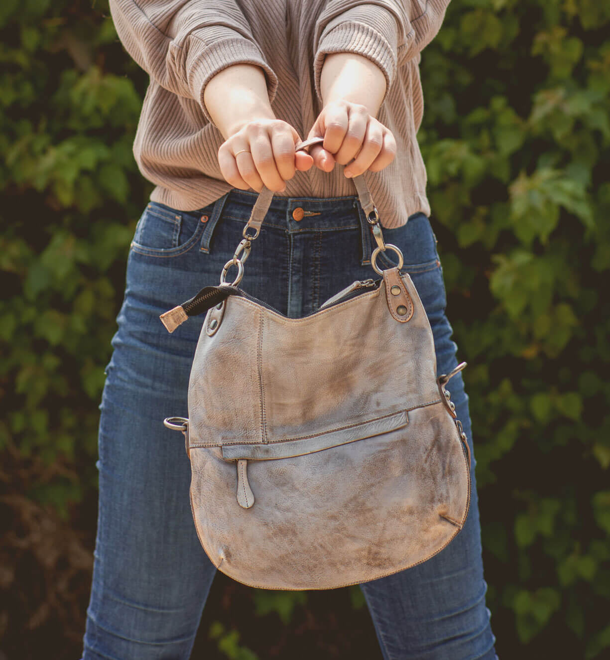 A woman is holding a Bed Stu Tahiti purse in her hands.