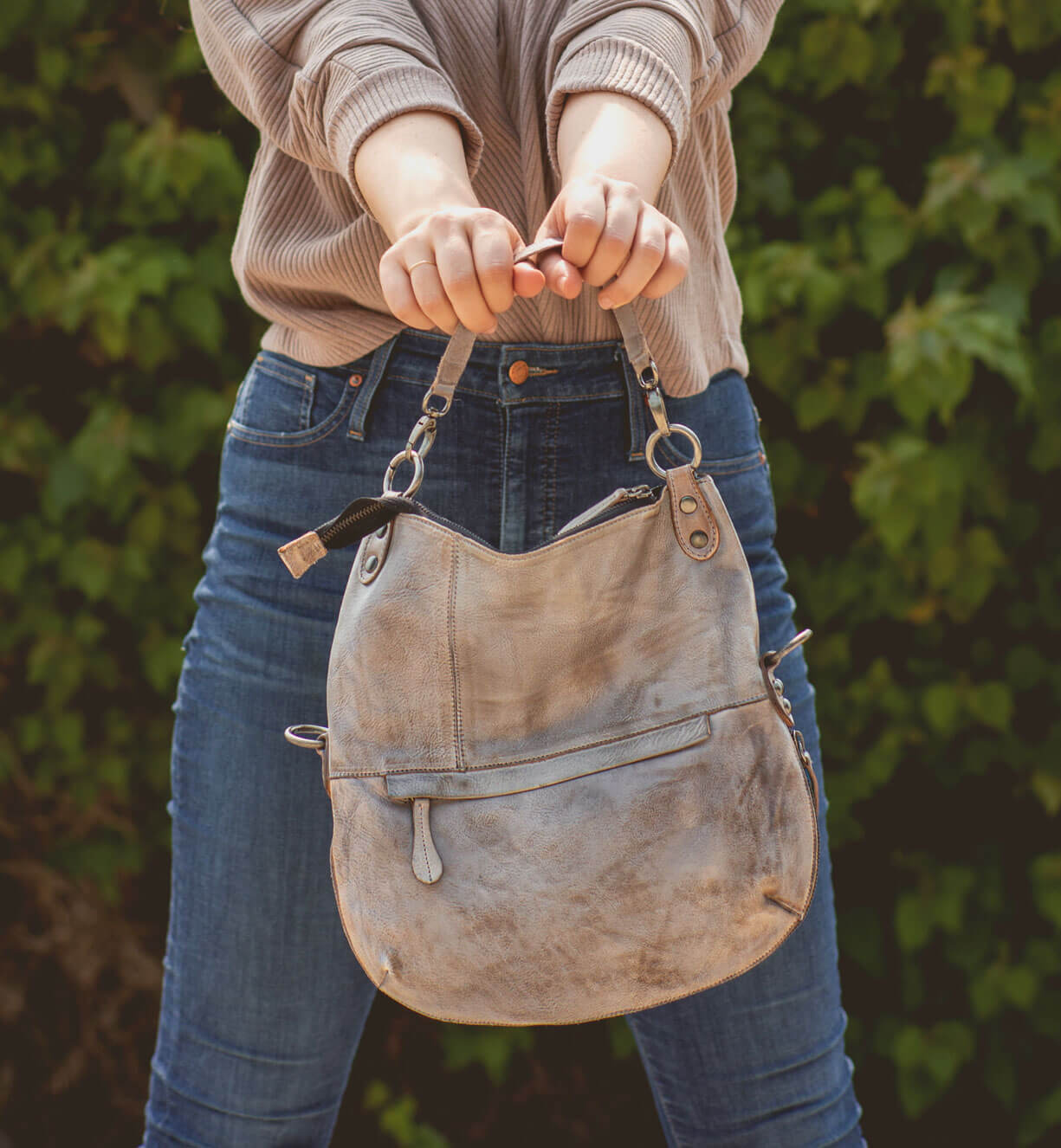 A woman is holding a Bed Stu Tahiti purse in her hands.