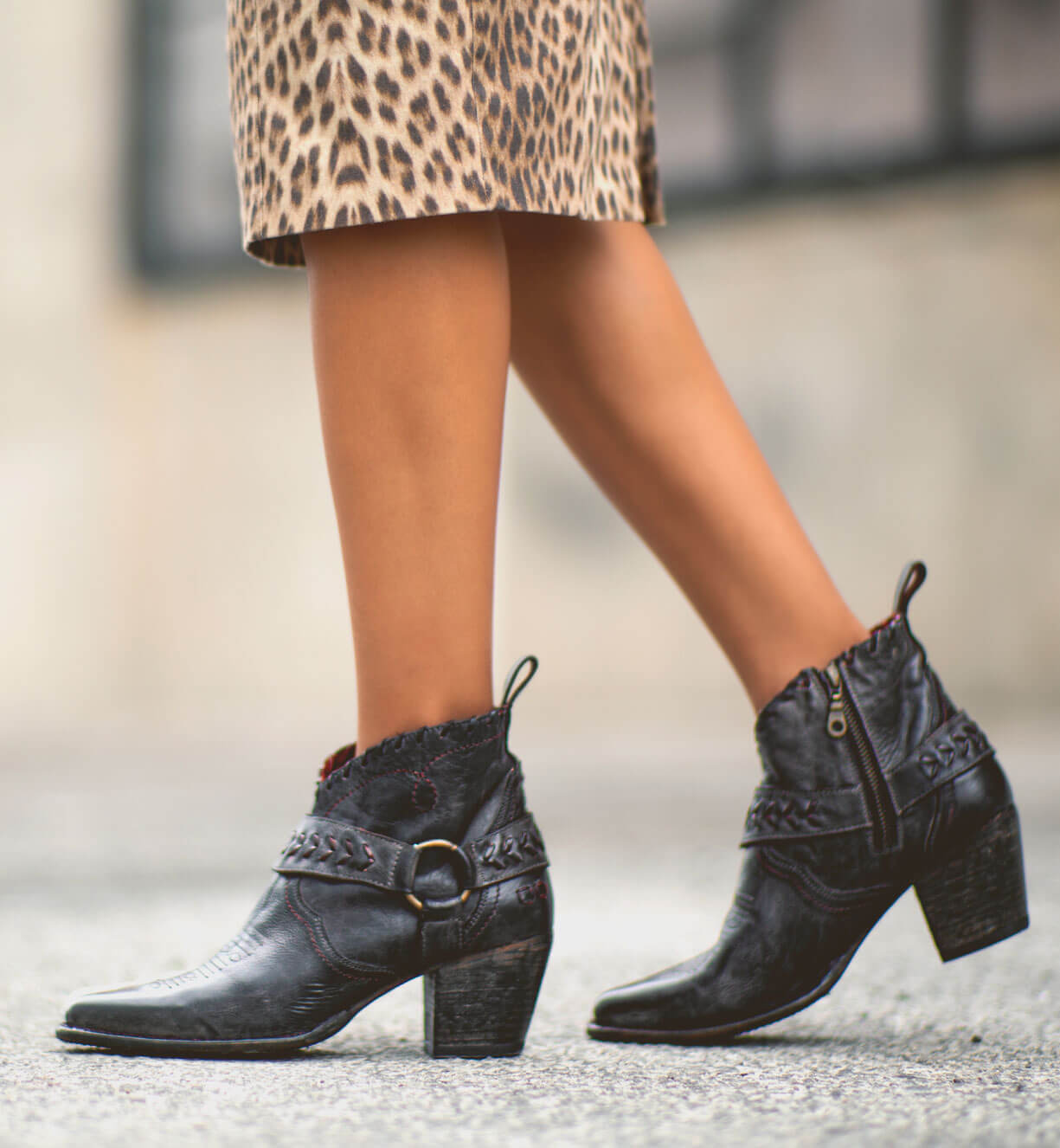 A woman wearing a leopard Tania skirt and black Bed Stu ankle boots.
