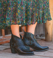 A woman wearing black Bed Stu cowboy boots and a floral skirt named Tania.