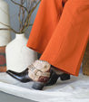 A woman wearing orange pants and a pair of brown Bed Stu Tania cowboy boots.