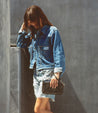 A woman holding a Bed Stu Templeton II black pure leather clutch.