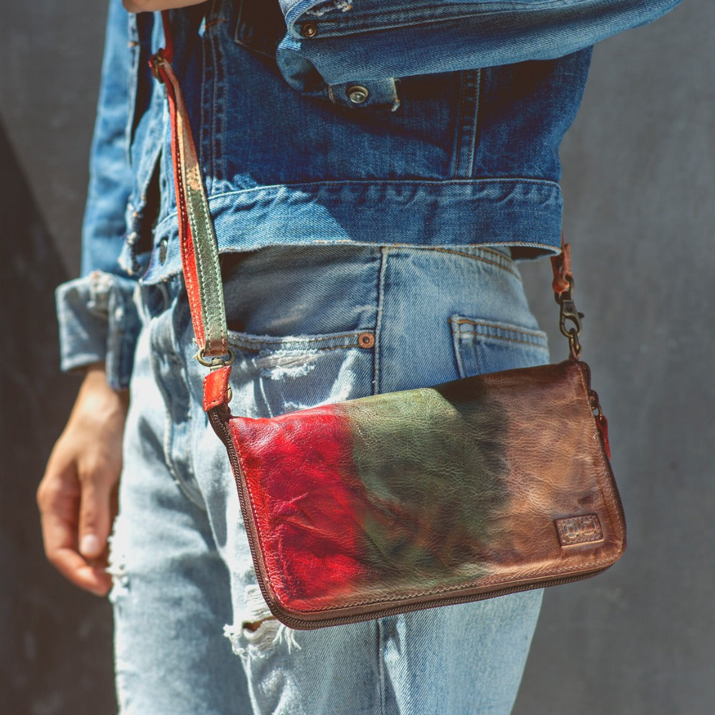 A woman wearing a Bed Stu Templeton II colorful leather clutch.