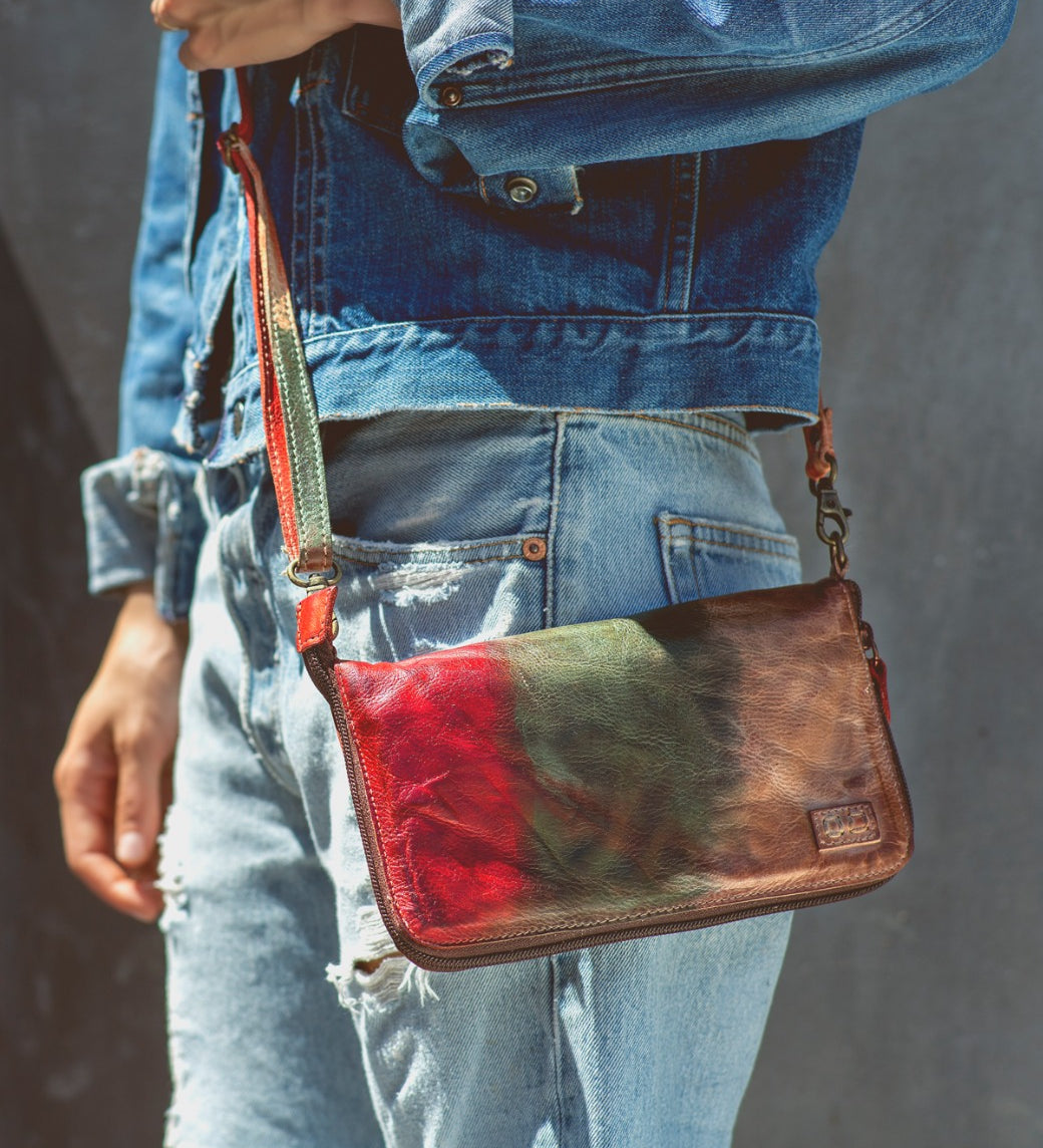 A woman wearing a Bed Stu Templeton II colorful leather clutch.