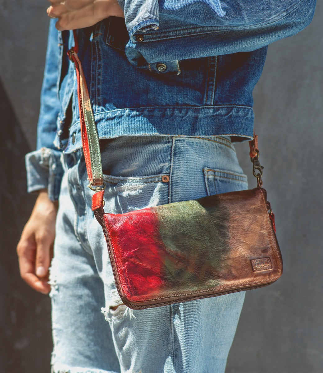 A woman wearing a Bed Stu Templeton II colorful leather clutch.