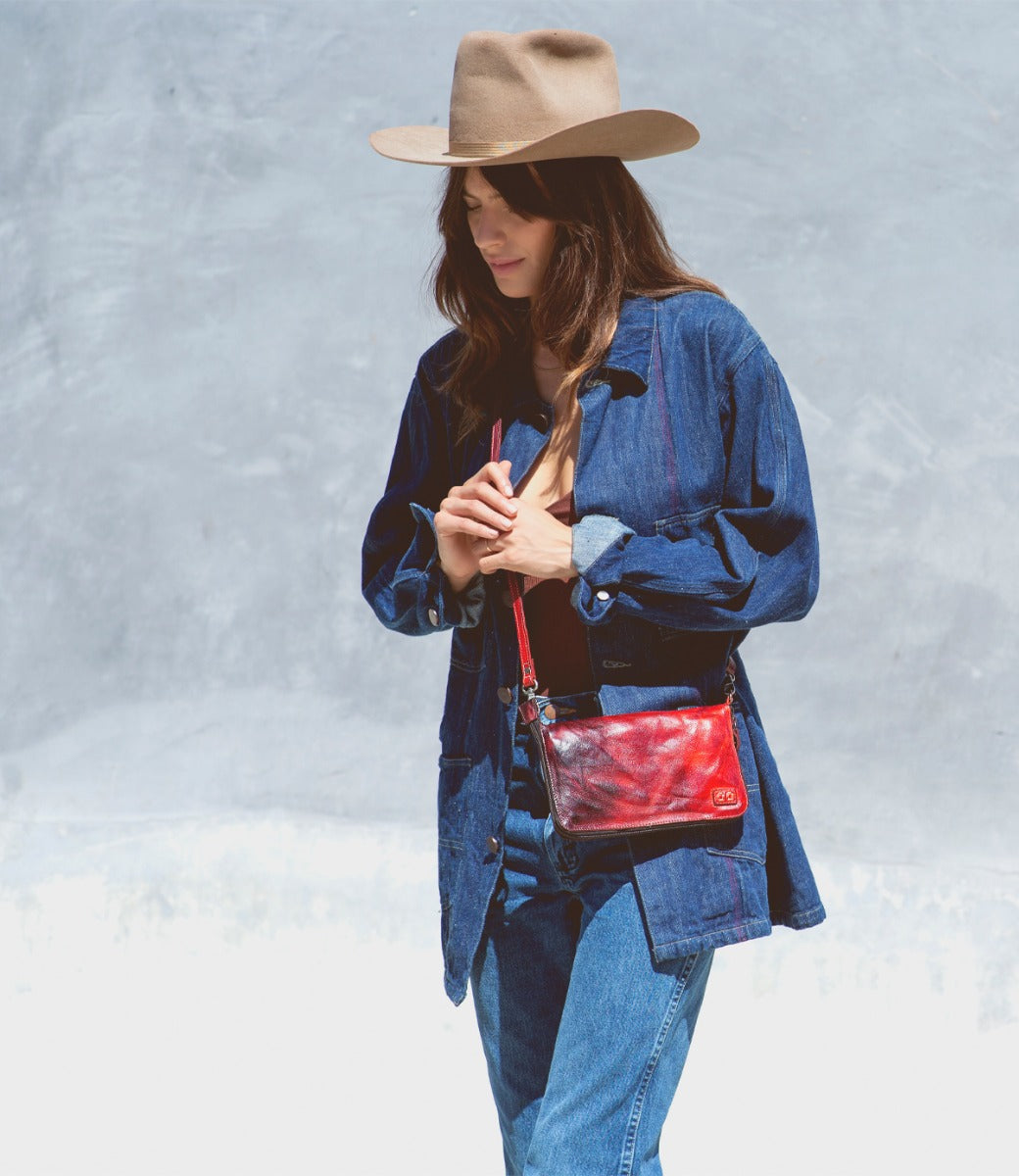 A woman wearing a Bed Stu Templeton II red leather clutch.