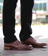 A man wearing Bed Stu Thorn shoes standing on a sidewalk.