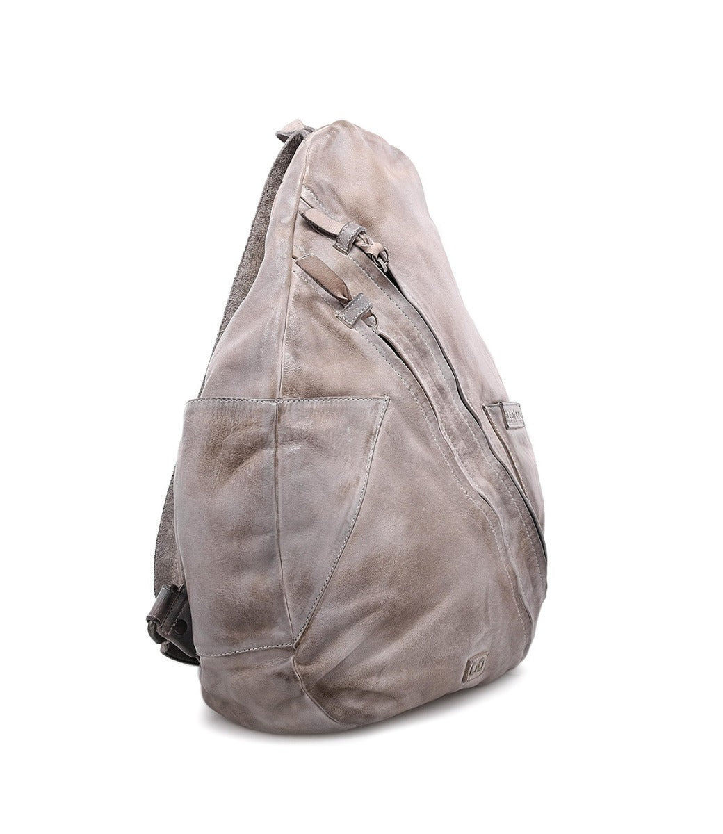 A grey leather Tommie sling bag on a white background by Bed Stu.