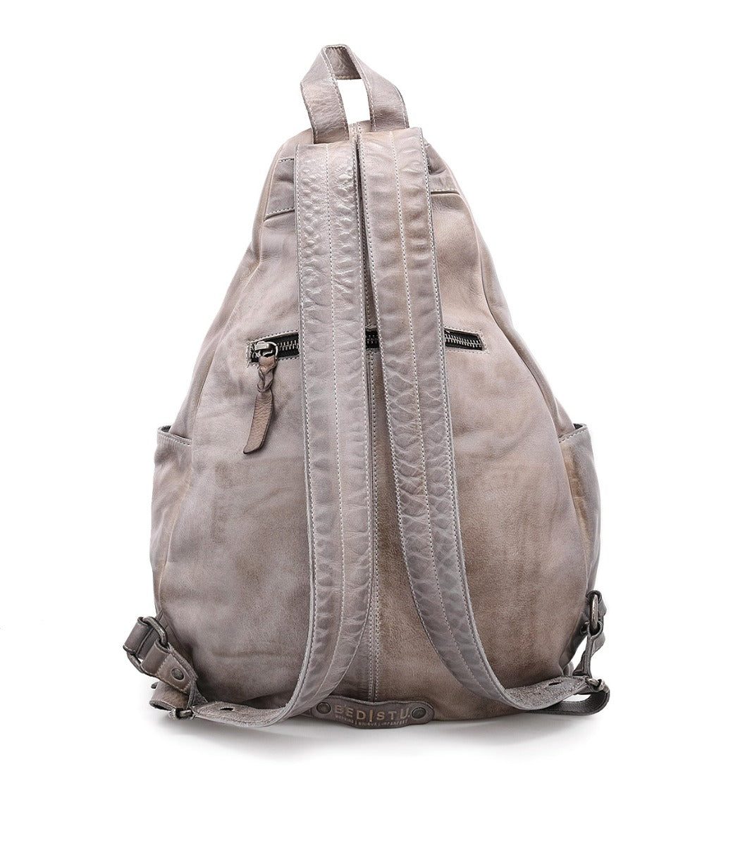 A Tommie backpack by Bed Stu, made of grey leather with zippers on the back.