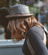 A woman wearing a Turino hat and Bed Stu backpack.