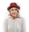 A woman wearing a red leather Bed Stu Turino fedora hat.
