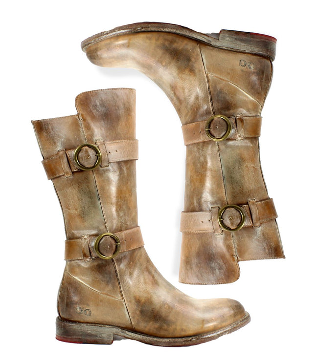 A pair of worn, light-brown Bed Stu "Turn" leather boots with buckles and straps, crafted from vegetable-tanned leather. The Goodyear welted construction ensures durability, despite the soles showing signs of wear and visible scuff marks.
