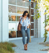 A woman wearing jeans holding an Amelie bag by Bed Stu.