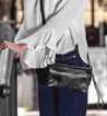 A woman in white shirt and jeans wearing a Bed Stu Cadence black cross body bag.