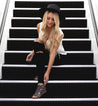 A blonde woman sitting on the stairs in a Claire by Bed Stu hat.